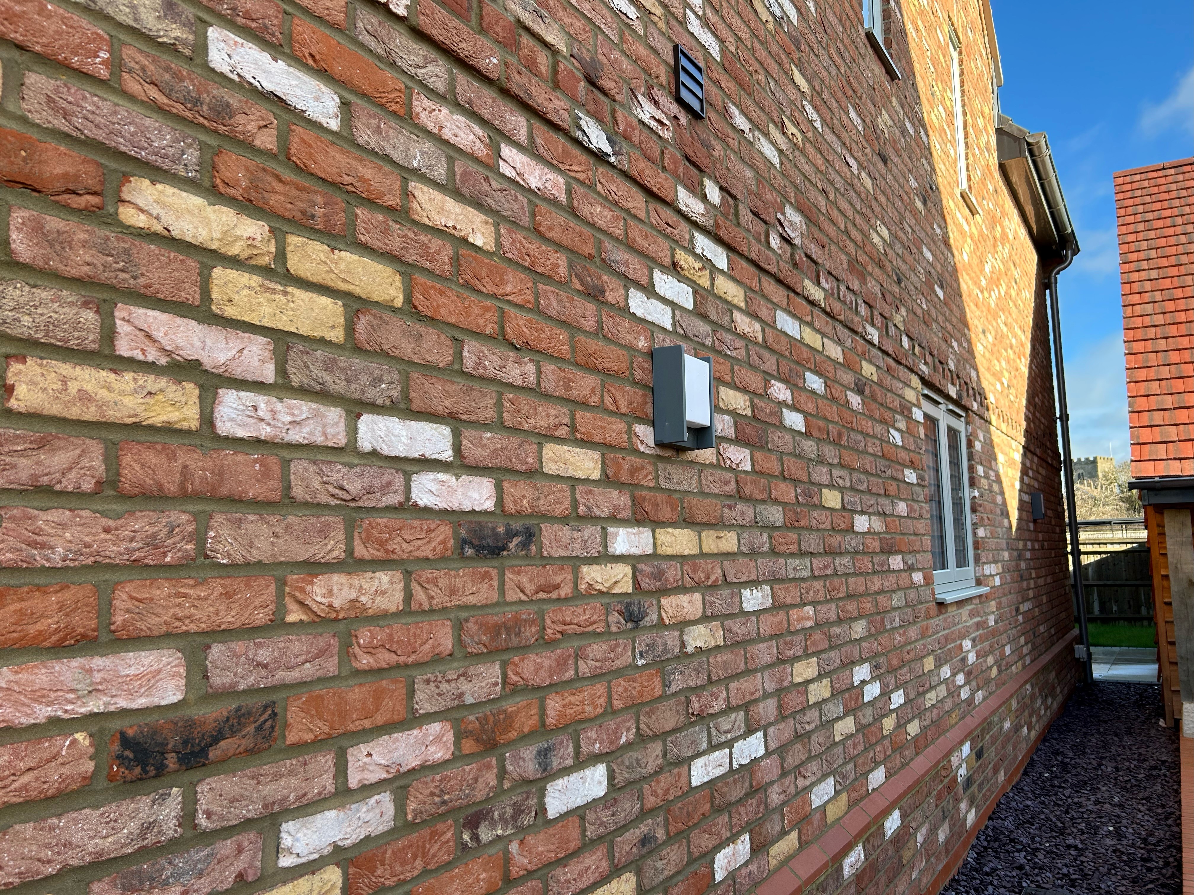 Close up of a tumbled brick, showing chipped and weathered brickwork.