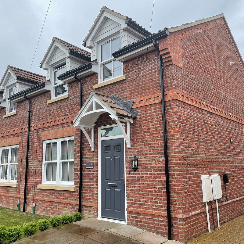 New collection of houses constructed in a red brick with cast stone window cills.