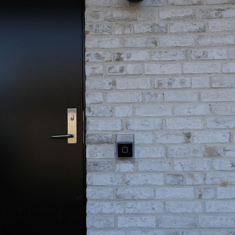 Black doorway complemented by the frosted white brick.