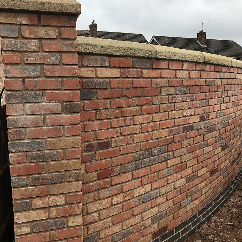 Close up of a tumbled wall with cast stone copings.
