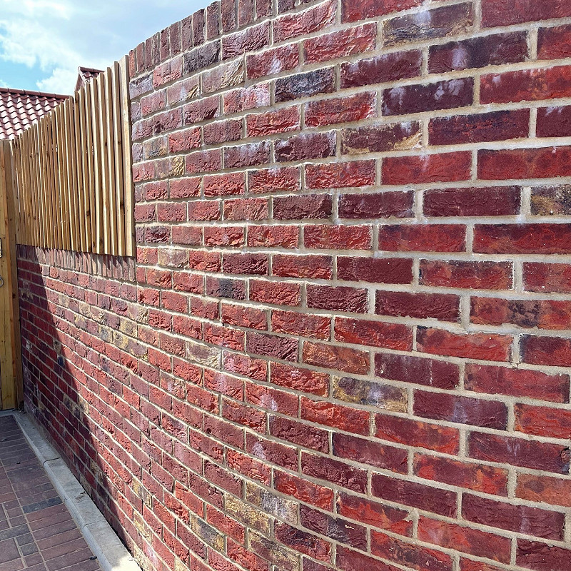 Curved wall constructed in a red multi.