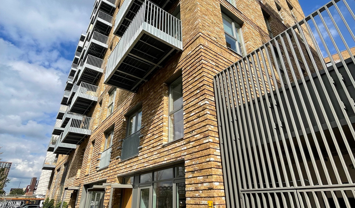 Facade of a contemporary Greenwich apartment complex with historical brickwork.