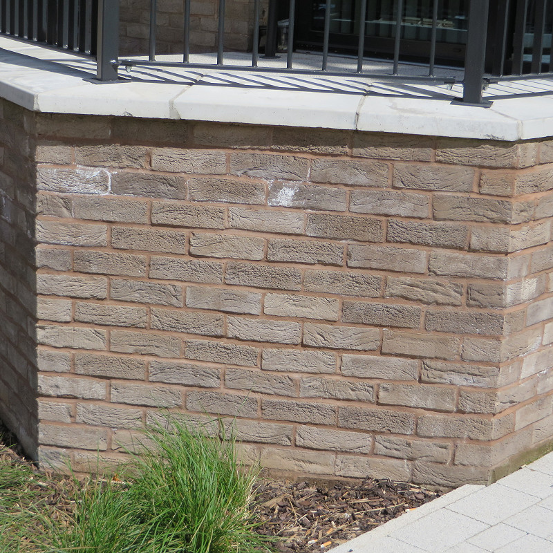 Close up of a bay window constructed in a grey brick.