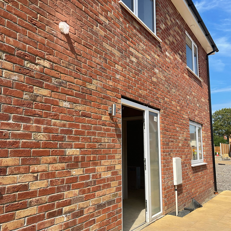 image of a house constructed in a rustic red multi brick.