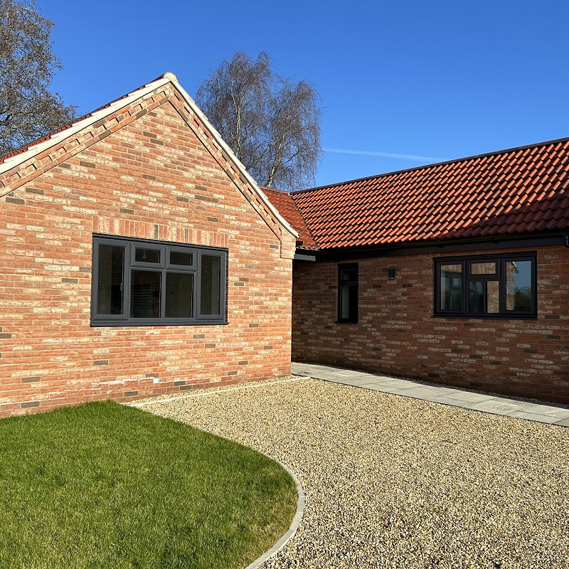 a bungalow constructed in a rustic red multi brick.