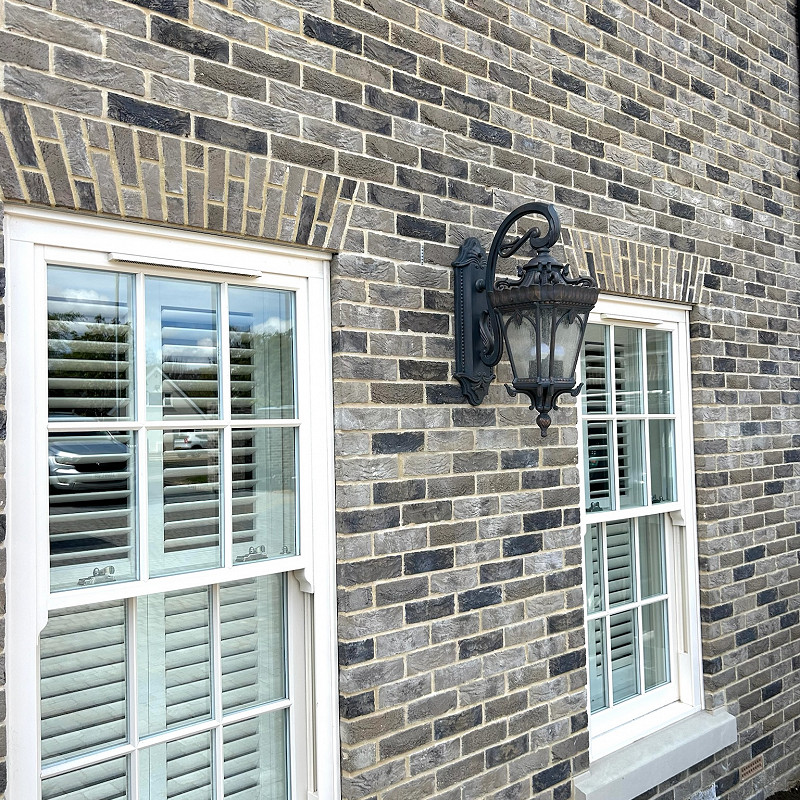 Traditional Black Lantern featured on a grey multi brick wall.