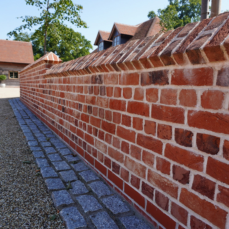 Close up of a rustic red multi brick with cast stone features.