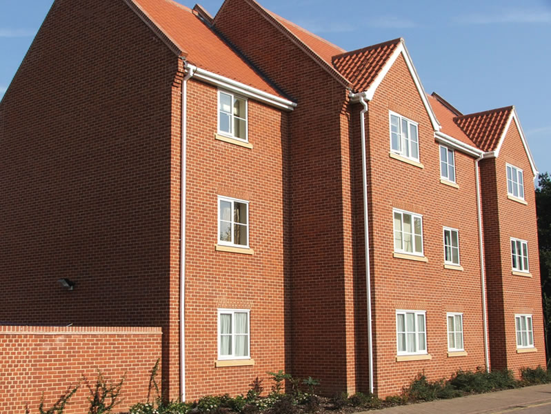 Block of flats constructed with flat textured red blend bricks.
